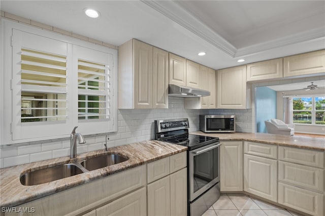 kitchen with light tile patterned floors, light stone counters, stainless steel appliances, under cabinet range hood, and a sink