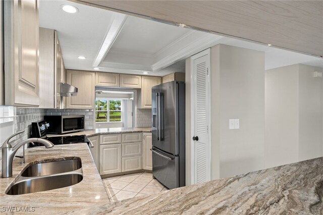 kitchen with sink, stainless steel appliances, light stone counters, and backsplash