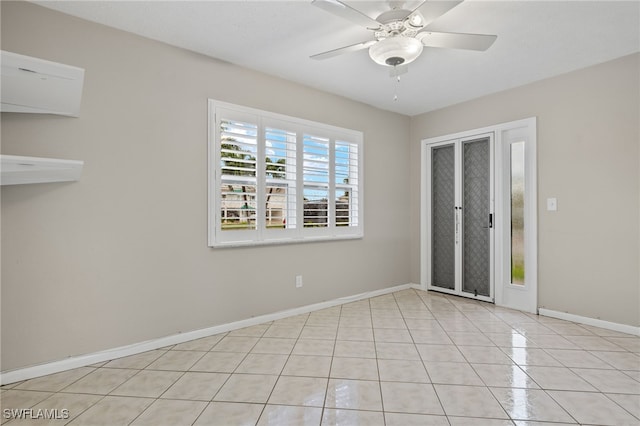 empty room featuring ceiling fan, baseboards, and light tile patterned floors