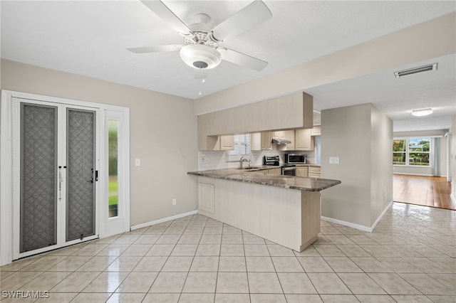 kitchen with visible vents, appliances with stainless steel finishes, a sink, dark stone counters, and a peninsula