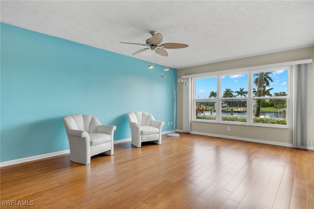 unfurnished room with ceiling fan, a textured ceiling, and light hardwood / wood-style flooring