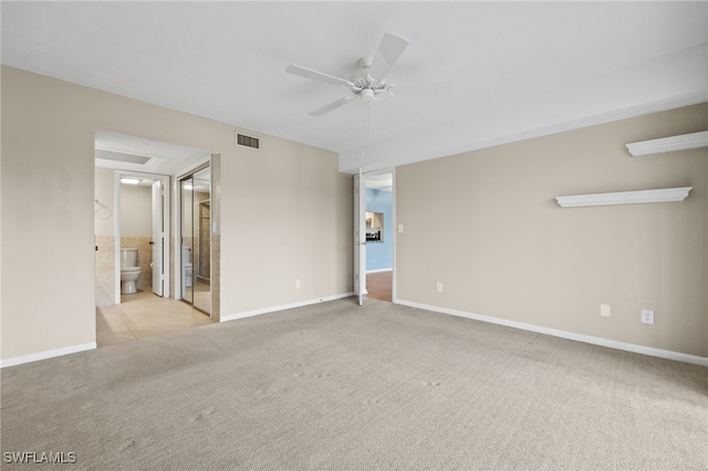 spare room featuring a ceiling fan, visible vents, light carpet, and baseboards