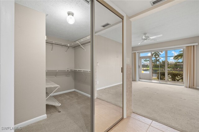 walk in closet featuring ceiling fan and light carpet