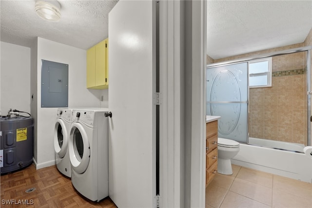 washroom featuring cabinet space, electric panel, washer and dryer, a textured ceiling, and water heater