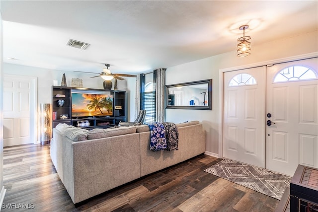 living room with a healthy amount of sunlight, dark wood-type flooring, and ceiling fan