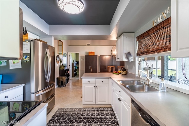 kitchen featuring white cabinetry, appliances with stainless steel finishes, a raised ceiling, and sink