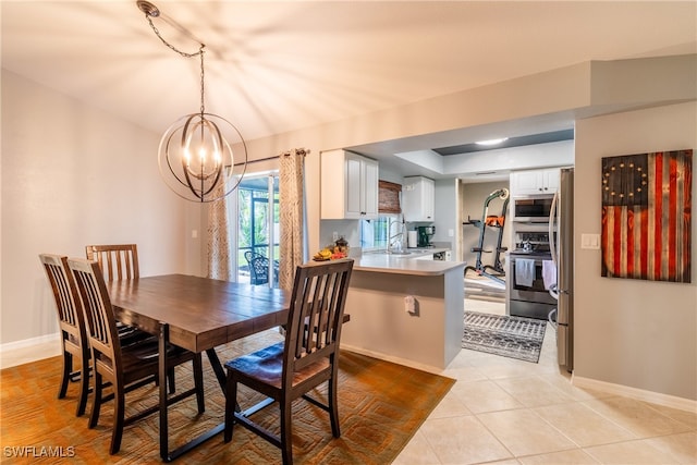 tiled dining room featuring an inviting chandelier and sink