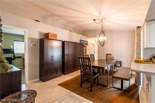 dining space featuring light tile patterned flooring, lofted ceiling, and a chandelier