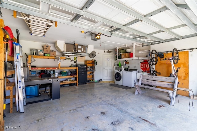 garage with a workshop area, a garage door opener, and washer and dryer