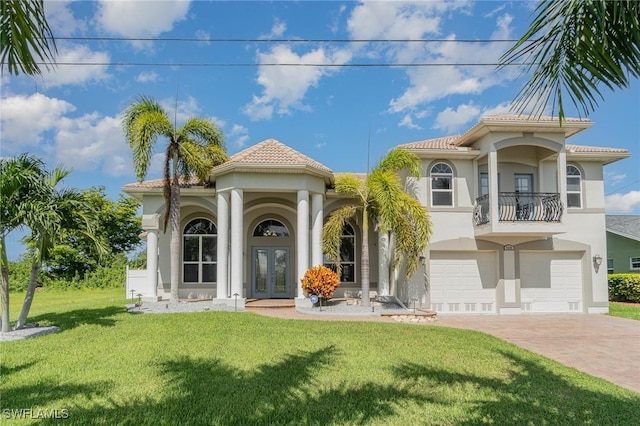 mediterranean / spanish-style house featuring a balcony, a front lawn, french doors, and a garage