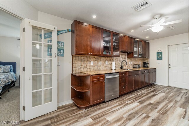 kitchen featuring sink, decorative backsplash, stainless steel dishwasher, light carpet, and ceiling fan