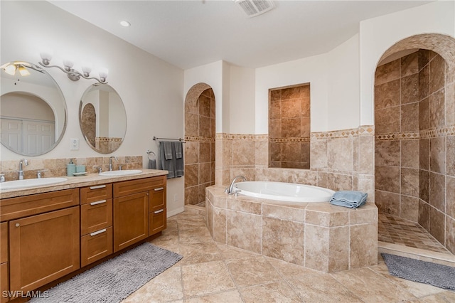 bathroom featuring tile patterned floors, vanity, shower with separate bathtub, and tile walls