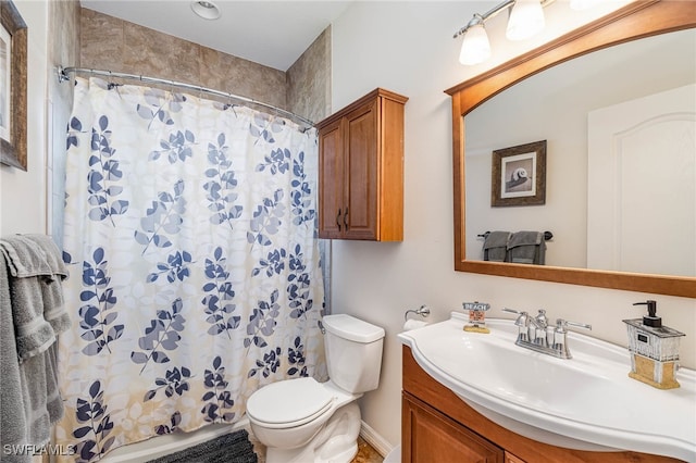 bathroom featuring toilet, vanity, and a shower with curtain