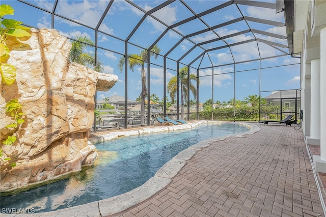 view of swimming pool with a patio, pool water feature, and a lanai