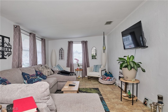 living room with light tile patterned flooring and crown molding