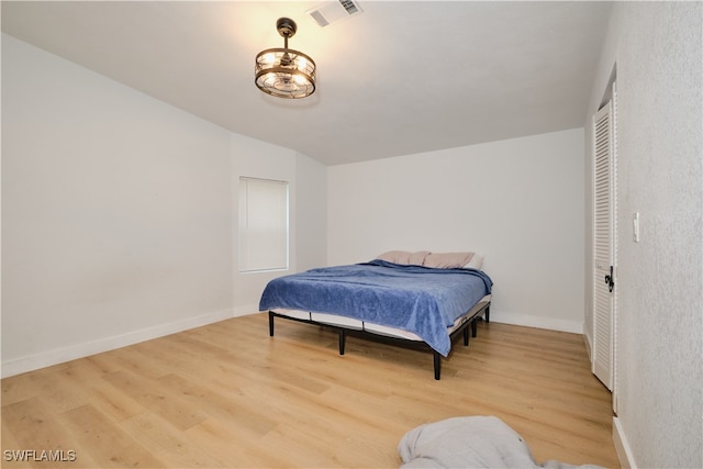 bedroom with vaulted ceiling and light wood-type flooring