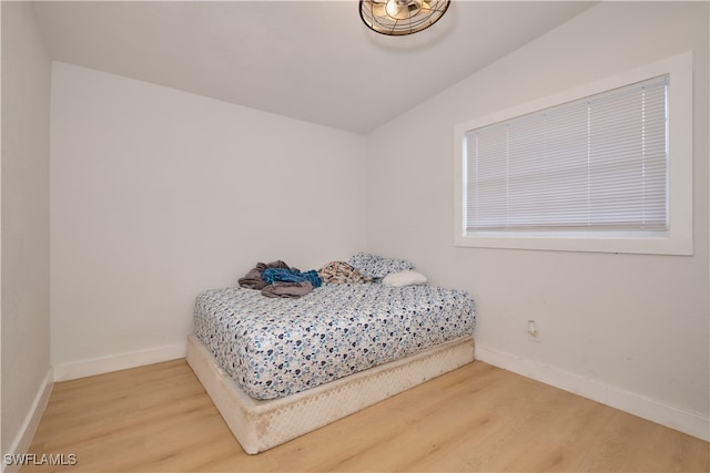 bedroom with light hardwood / wood-style flooring and lofted ceiling