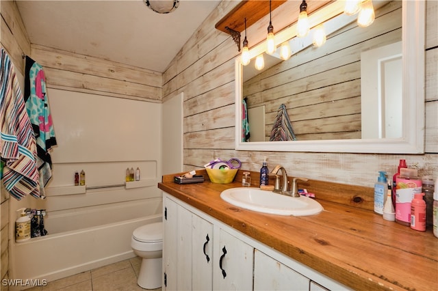 bathroom featuring tile patterned flooring, wood walls, vanity, and toilet