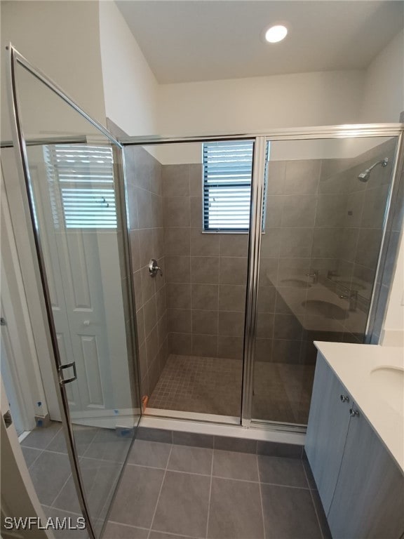 bathroom with tile patterned flooring, vanity, and a shower with shower door