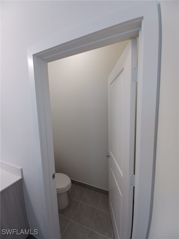 bathroom with tile patterned flooring, toilet, and vanity