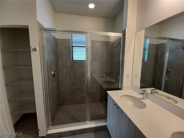 bathroom with tile patterned floors, a shower with door, and vanity