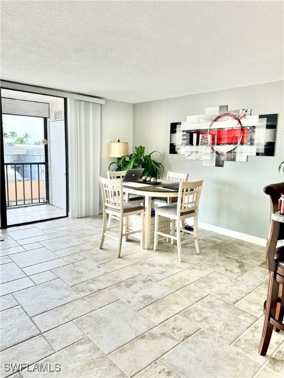 tiled dining room with a textured ceiling