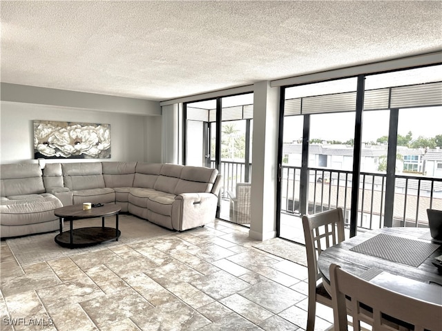 living room with a wealth of natural light, a textured ceiling, and light tile patterned floors