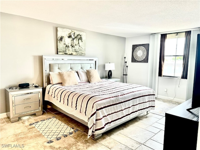 bedroom featuring light tile patterned flooring and a textured ceiling