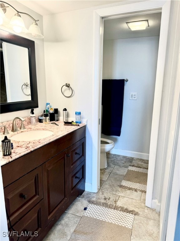 bathroom featuring tile patterned flooring, vanity, and toilet