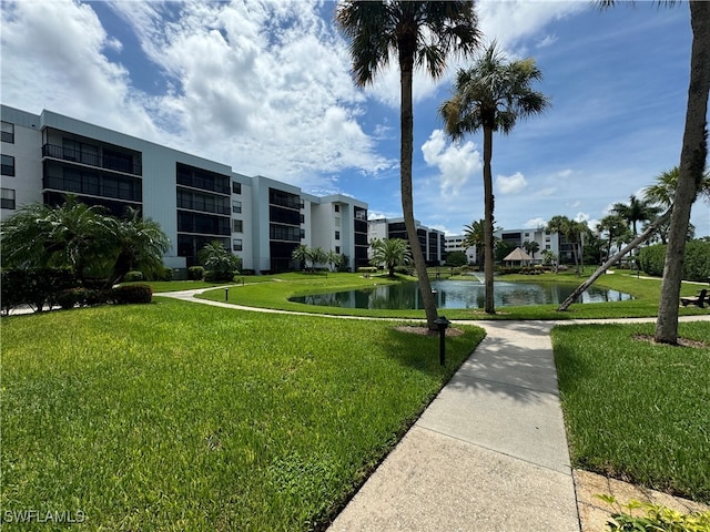 surrounding community with a lawn and a water view