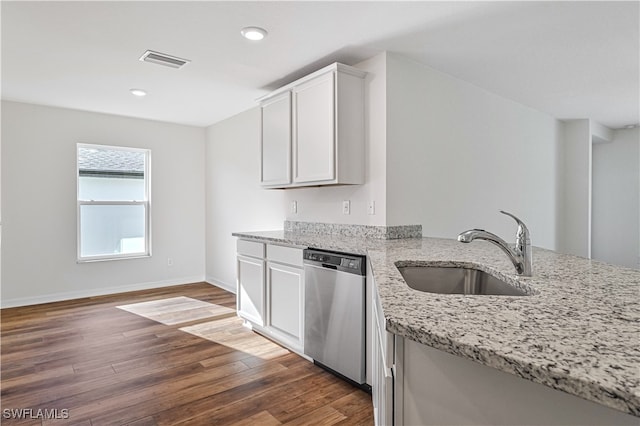 kitchen featuring stainless steel dishwasher, dark wood-type flooring, white cabinets, light stone countertops, and sink