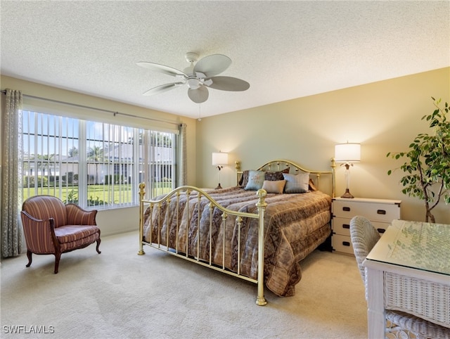 carpeted bedroom with a textured ceiling and ceiling fan