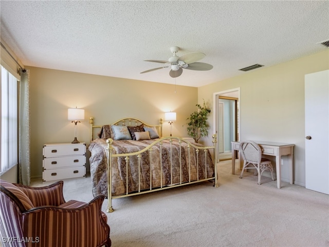 bedroom featuring ceiling fan, light colored carpet, and a textured ceiling