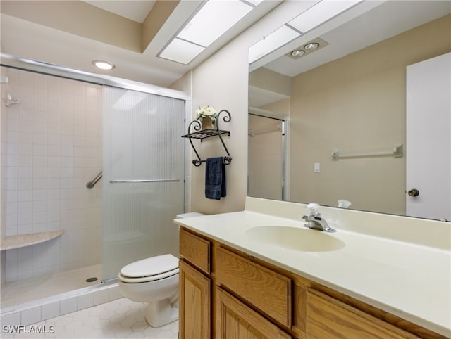 bathroom with tile patterned flooring, a shower with door, vanity, and toilet