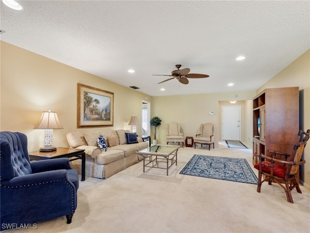 living room featuring light carpet, a textured ceiling, and ceiling fan