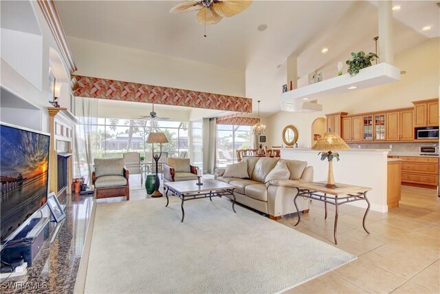 living room with ceiling fan, high vaulted ceiling, and light tile patterned floors