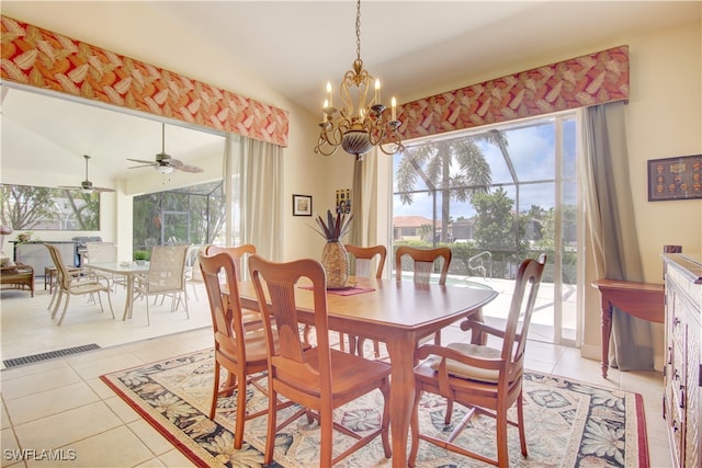 tiled dining area with ceiling fan with notable chandelier and vaulted ceiling