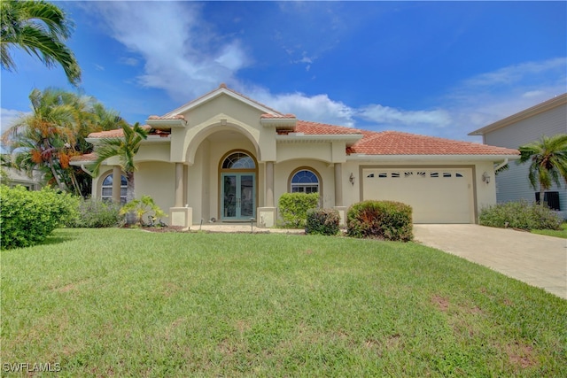 mediterranean / spanish house featuring a front lawn and a garage