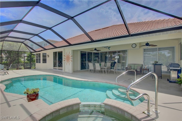 pool at dusk featuring ceiling fan, glass enclosure, grilling area, and a patio area