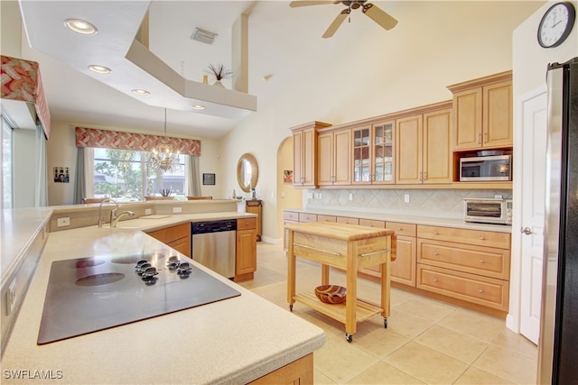 kitchen featuring backsplash, sink, appliances with stainless steel finishes, ceiling fan with notable chandelier, and light tile patterned floors