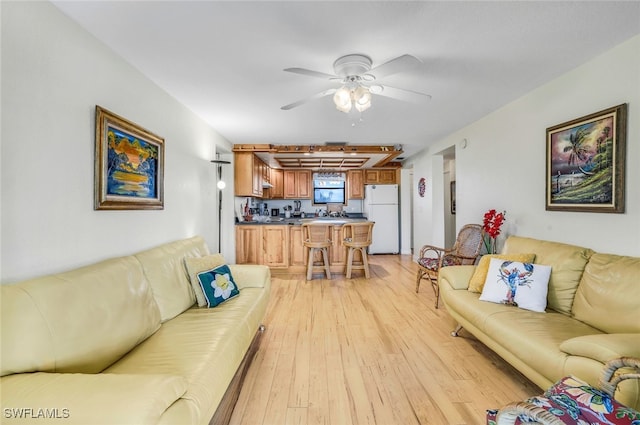 living area featuring light wood-style floors and ceiling fan