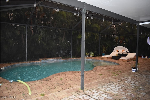 view of swimming pool featuring a patio and a lanai