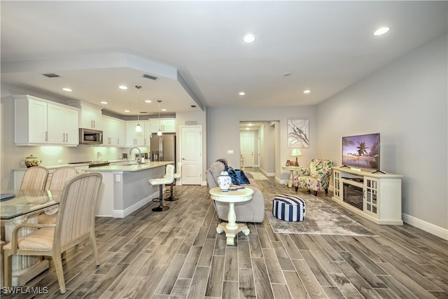 living room with light wood-type flooring and sink