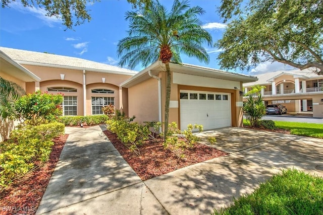 view of front of property with a garage, driveway, and stucco siding