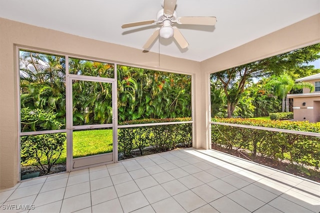 unfurnished sunroom featuring ceiling fan