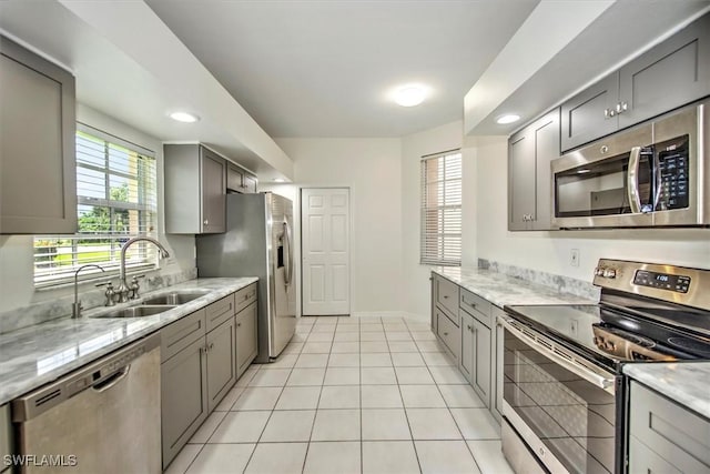 kitchen with gray cabinets, stainless steel appliances, and a sink