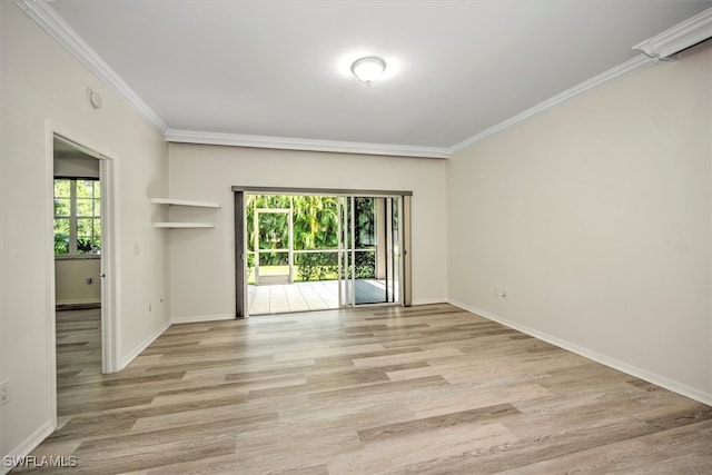 spare room featuring a wealth of natural light, ornamental molding, and light wood-type flooring