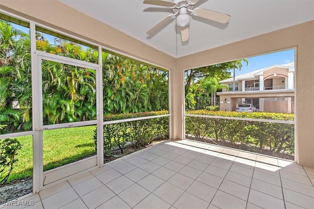 unfurnished sunroom with ceiling fan