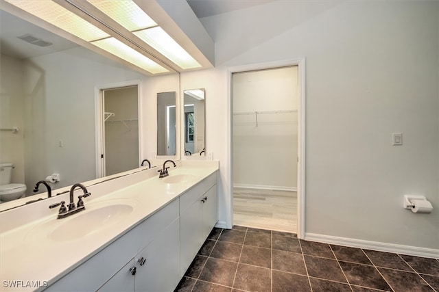 bathroom featuring toilet, vanity, and tile patterned floors