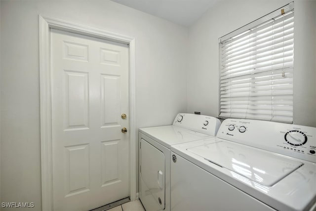 laundry area with light tile patterned floors and separate washer and dryer